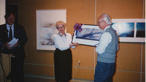 Paul Olson holds a framed print of Keith Jacobshagen's "Havelock Elevator, Evening of Ash Wednesday."
