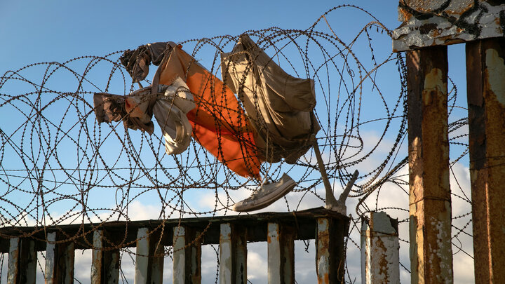 Clothing hangs stuck in razor wire atop the U.S.-Mexico border fence on Sept. 28, 2019, near Tijuana, Mexico.